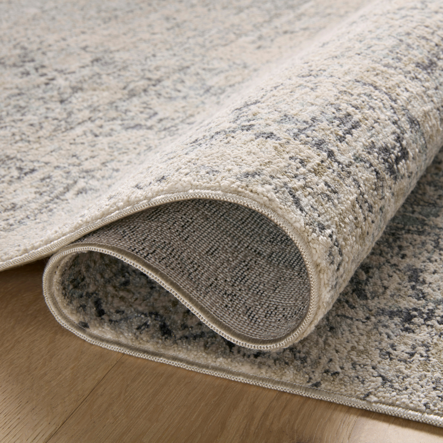 Edge and backing detail of Homvirex Alie Stone Mist rug